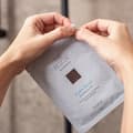 Woman opening The Hydro Bomb sheet mask