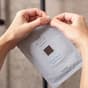 Woman opening The Hydro Bomb sheet mask